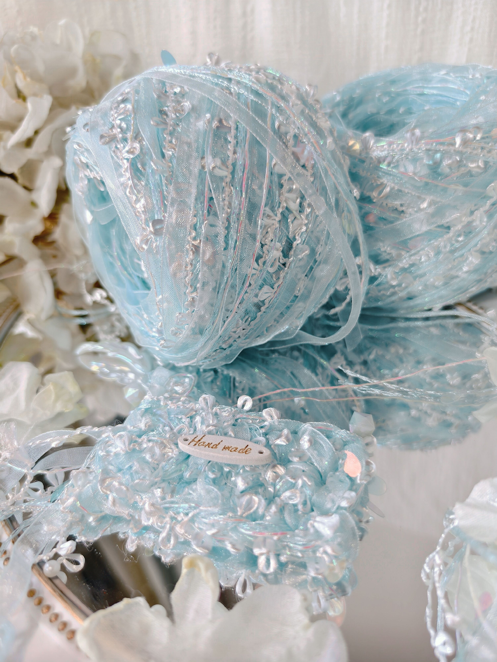 Iridescent blue textured art yarn ball with shimmering fibers and decorative details