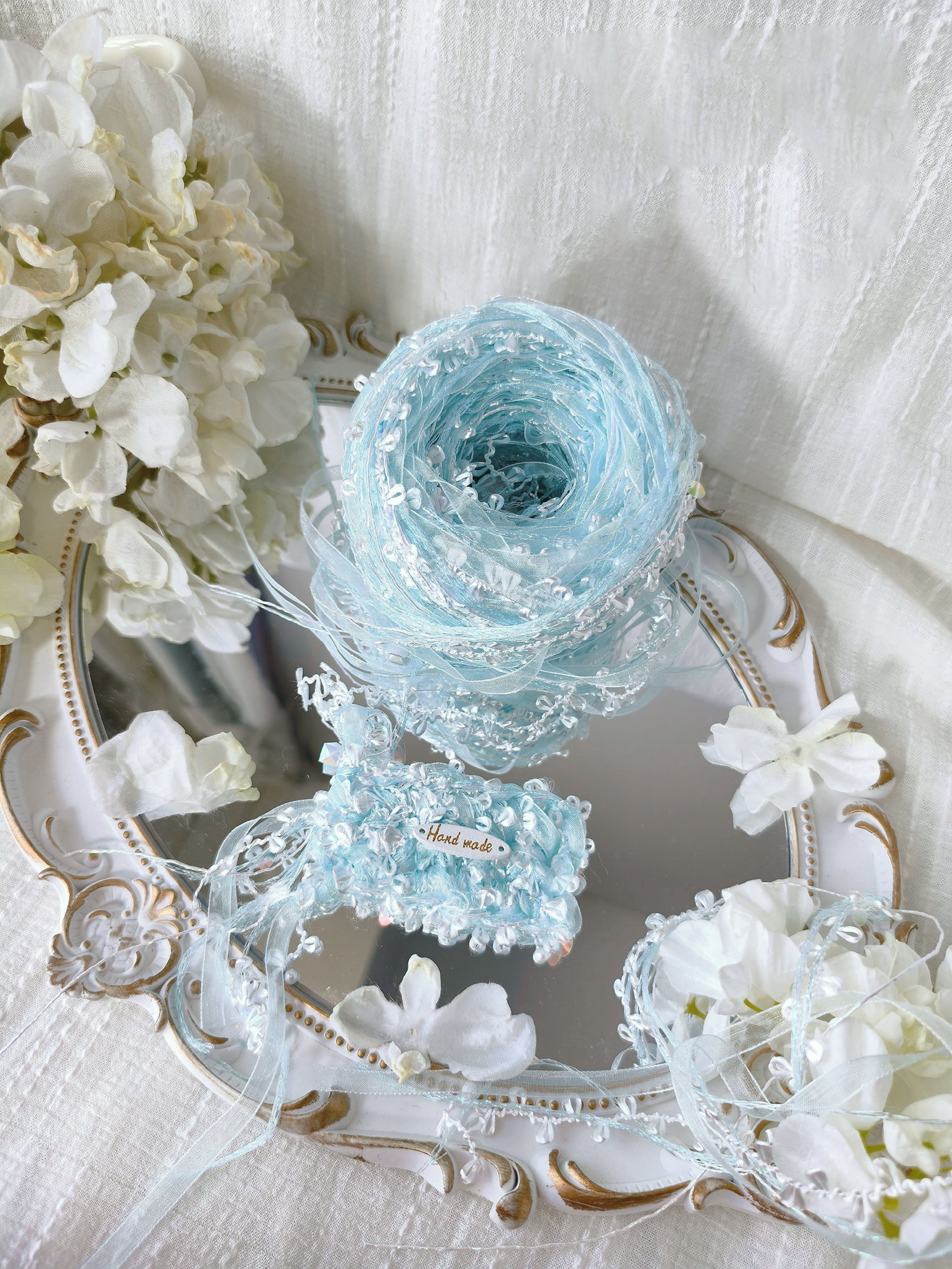 Iridescent blue textured art yarn with layered fibers and shimmering details.