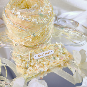 Handmade yellow textured art yarn ball with decorative fibers