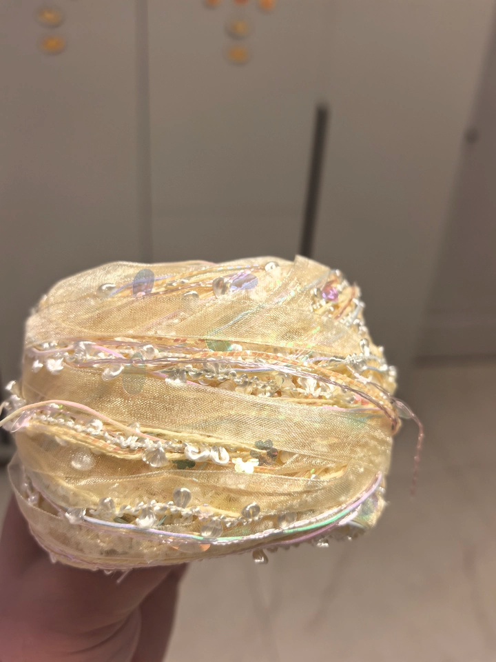 Handmade yellow art yarn with layered textured fibers and decorative details