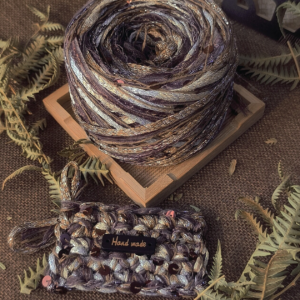 Handmade brown textured art yarn ball with decorative fibers