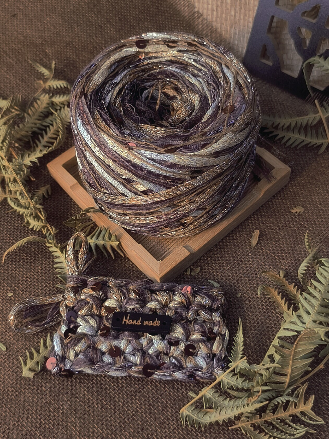 Handmade brown textured art yarn ball with decorative fibers