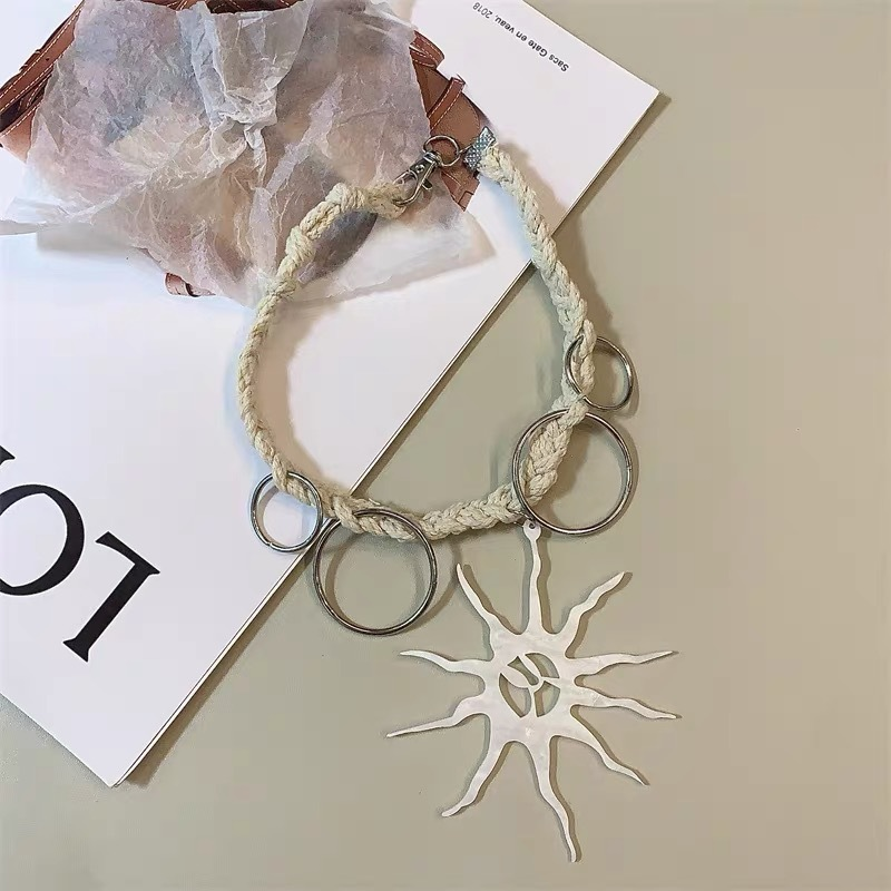 Boho sun pendant necklace featuring a large textured sun pendant and woven-style cord