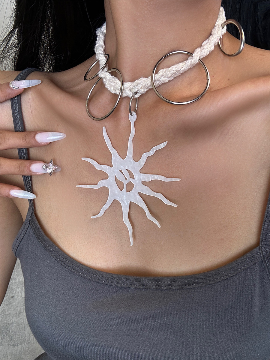 Sun pendant necklace with textured white sun design and silver-tone ring details worn with a boho outfit