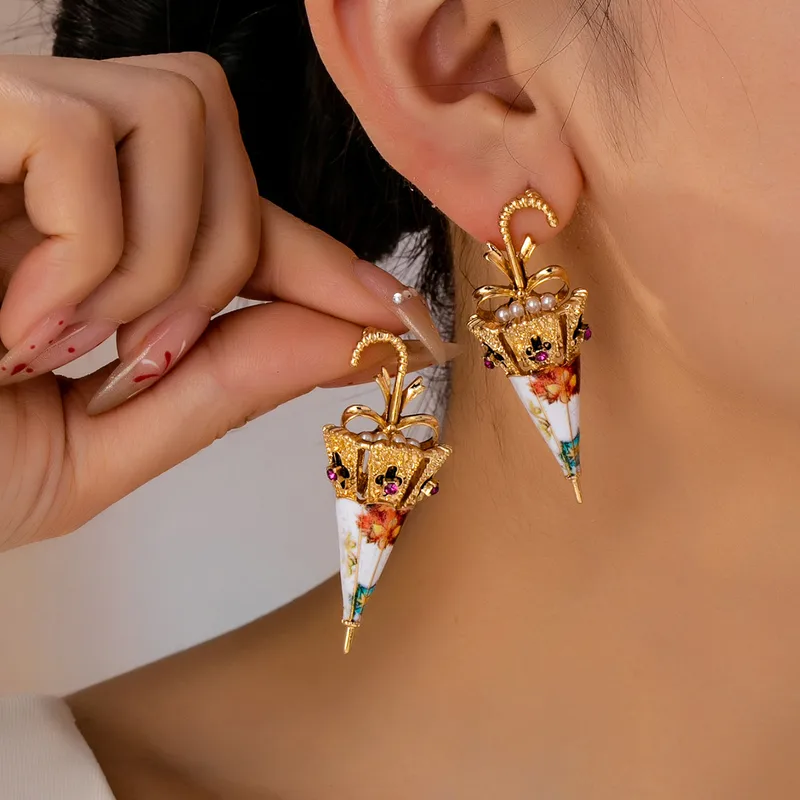 Colorful umbrella earrings worn by a woman